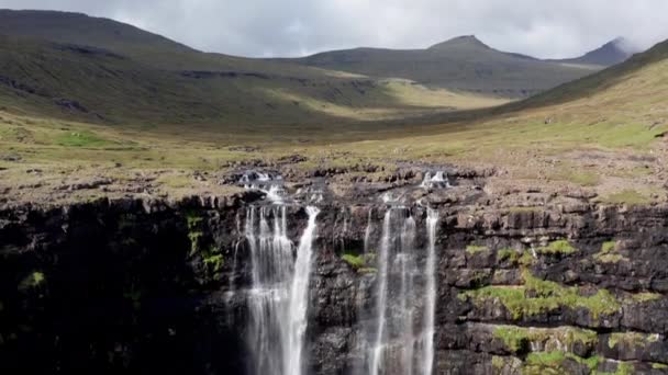 フェロー諸島の楽しいフォッサ滝の空中 ワイルドロッキーヒルサイドの雄大な滝 カメラがダウン — ストック動画