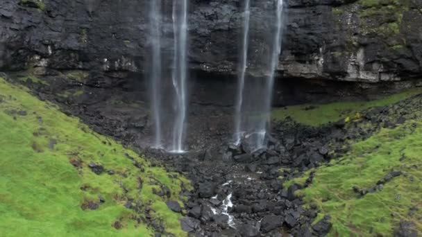 フェロー諸島の楽しいフォッサ滝の空中 ワイルドロッキーヒルサイドの雄大な滝 スローモーションティルトアップショット — ストック動画
