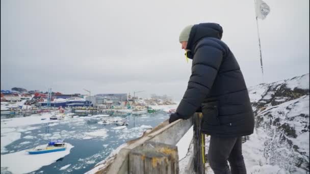 Medium Arcing Shot Man Winter Coat Looking Frozen Harbour Town — Stock Video