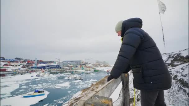 Medium Arcing Shot Man Winter Coat Looking Frozen Harbour Town — Αρχείο Βίντεο