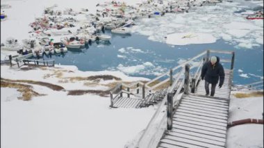 Grönland, Avannaata Belediyesi, Ilulissat şehrinde kar üzerinde yürüyen adamın yavaş çekim görüntüsü.