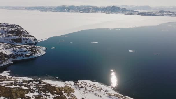 太陽光に照らされた海と氷の海岸線を横断する広い無人機シシミット ケッカタ市 グリーンランド — ストック動画