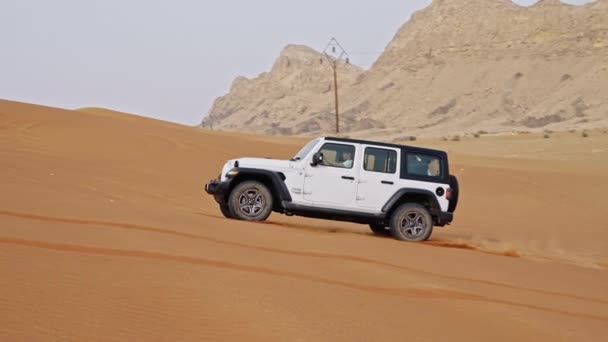 ドバイの砂漠で砂丘を運転するホワイトジープ — ストック動画