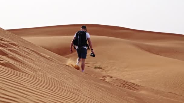 Wide Slow Motion Tracking Shot Man Backpack Hiking Sand Dunes — Wideo stockowe