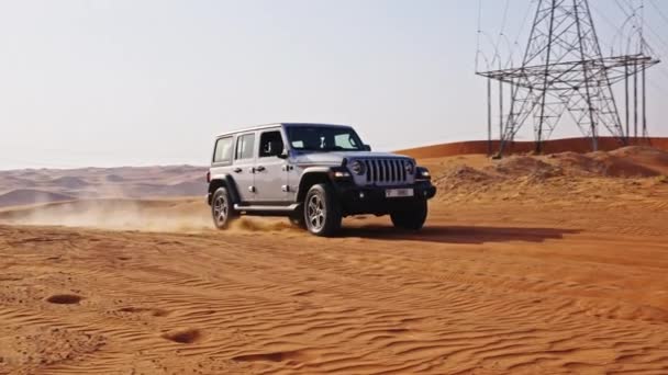 ドバイで砂漠をドライブするジープの広いスローモーショントラッキングショット — ストック動画