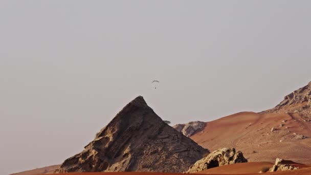 การเคล อนไหวช ากว างภาพคงท ของบ คคล Paragliding งการก วของห นในทะเลทรายด — วีดีโอสต็อก