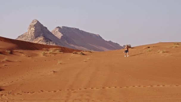 Wide Slow Motion Handheld Shot Shirtless Man Walking Desert Dubai — Stockvideo