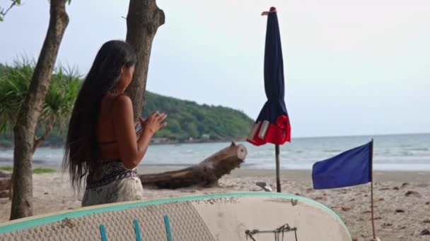 Uzun Siyah Saçlı Bir Kadının Tayland Sörf Tahtasının Yanındaki Kumsalda — Stok video