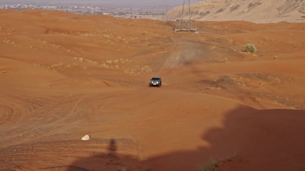 砂漠を通ってジープの運転の広いスローモーション追跡ショットとドバイで砂の上にスキー — ストック動画