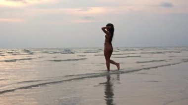 Yavaş çekim Bikini Bikini 'deki güzel kadının sahilden denize yürüyüşü, Tayland
