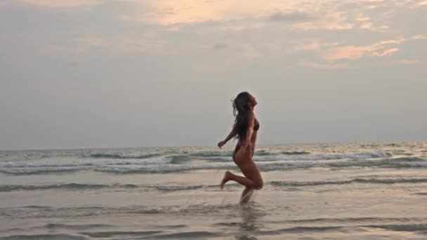 泰国日落时在海上奔跑的年轻女子慢动作全景跟踪镜头 — 图库视频影像