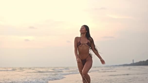 泰国落日时分 美丽的年轻女子在海上奔跑和微笑的宽慢动作跟踪镜头 — 图库视频影像