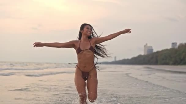 泰国落日时分 美丽的年轻女子在海上奔跑和旋转的宽慢动作跟踪镜头 — 图库视频影像