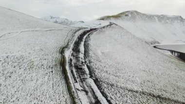 İzlanda 'nın Highlands bölgesindeki Karlı Toprak Yol' da Araba Sürüşü. Geniş açı. Kamera Arabayı İzliyor