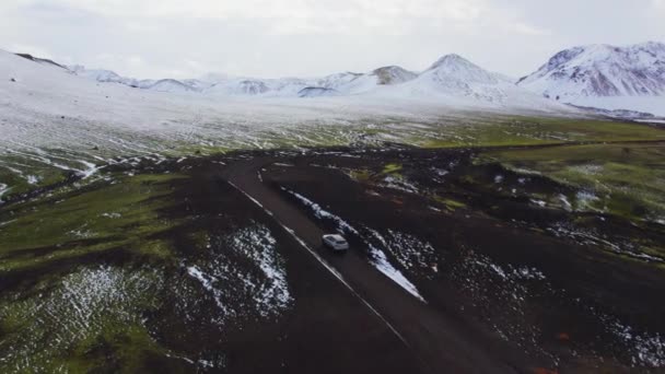Carro Dirigindo Uma Estrada Sujeira Lama Para Montanhas Cobertas Neve — Vídeo de Stock