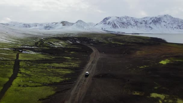 Aerial Car Driving Mud Dirt Road Majestic Snow Capped Mountains — Stockvideo