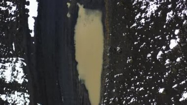 İzlanda 'daki Çamur Yolu' nda Su birikintisinin içinden geçen bir arabanın havası. Yukarıdan Aşağı Statik Çekim