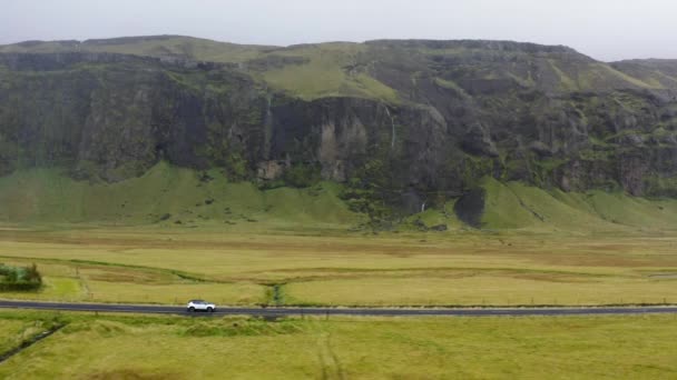 Aerial Car Driving Asphalt Road Green Fields Mountains Iceland Side — Stockvideo