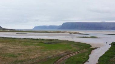 Nehrin Havası ve İzlanda 'da Araba Durmuş Kırsal Yol. Arka planda Görkemli Dağlarla Yeşil Çayırlar Arasındaki Nehir. Göz kamaştırıcı manzara. Panoramik Taşımacılık Çekimi