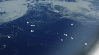 Arktik ve Atlantik Okyanusları ile çevrili Grönland uçağından çekilen yüksek açı, buzdağlarıyla çevrili.
