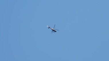 Aydınlık bir günde, Mavi Gökyüzünde Bir Helikopterin Dibe Bakışı. Kamera Helikopteri İzliyor