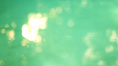 Parlak Yaz Gününde, Dalgalı Su Yüzeyi 'nde Bulanık Güneş Yansımaları Parlıyor. Odaklanmamış Vuruş