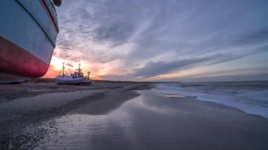 Timelapse of Picturesque Seascape at Sunset. Waves Are Crashing to the Coast With Fishing Boats Standing Ashore