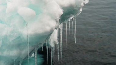 Medium Arcing Slow Motion Shot Of Icicles On Iceberg Over Sea, Greenland