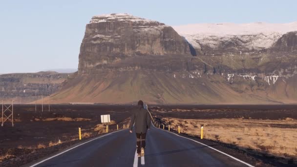 Back View Man Walks Empty Asphalt Road Front Majestic Mountains — ストック動画