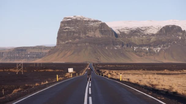 Man Happily Jumps Empty Asphalt Road Front Majestic Mountains Iceland — Vídeo de Stock
