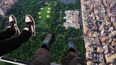 POV Shot of Two Men Legs Dangling Off a Helicopter Flying Over Central Park, New York
