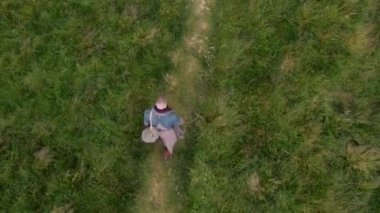 Yeşil Çayır 'da Yol Boyunca Yürüyen Bir Adam' ın Havadan Aşağı Görünümü. Kamera Uzaklaşıyor