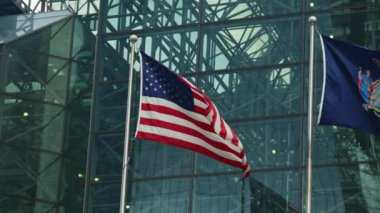 American National Flag Waving In Front a Modern Skyscraper Glass Facade. Slow Motion Shot