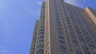 Low Angle Wide Point Of View Shot Moving Under New York City Blocks Of Apartments Under Blue Sky