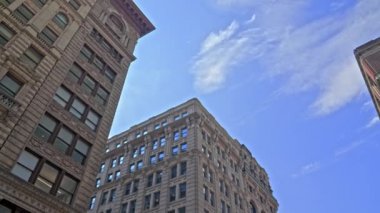 Low Angle Wide Panning Shot Of New York City Buildings And Apartments Under Blue Sky