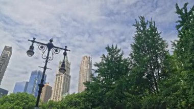 Dolly Wide Low Angle Shot Of New York Skyline Over Trees With Rockefeller Plaza And The Woolworth Building