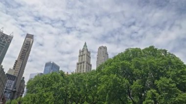 Dolly Wide Low Angle Shot Of New York Skyline Over Trees With Rockefeller Plaza And The Woolworth Building