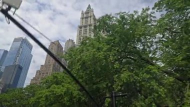 Dolly Wide Low Angle Shot Of New York Skyline Over Trees With The Woolworth Building