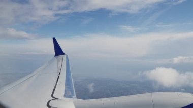 View Through Plane Window on an Aircrafts Wing, Engine and Passing By Clouds During the Flight. Beautiful Scenery Outside the Window
