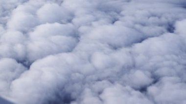 View Through Plane Window on Beautiful Sea of White and Fluffy Clouds During the Flight. Beautiful Scenery Outside the Window