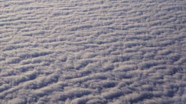 View Through Plane Window on Beautiful Sea of White and Fluffy Clouds During the Flight. Beautiful Scenery Outside the Window