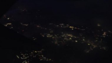 View Through Plane Window on a Night City Lights During the Flight. Panoramic Shot