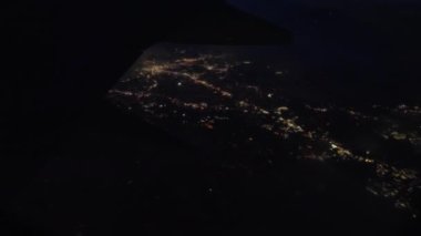 View Through Plane Window on a Night City Lights During the Flight. Panoramic Shot