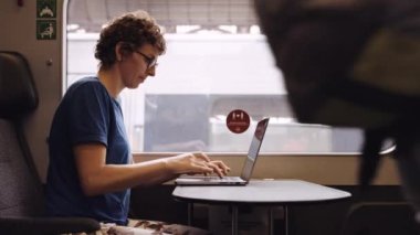 Woman with Curly Hairs and with Glasses On Working on a Laptop While Waiting for the Train Departure