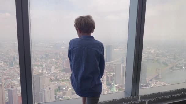 Medium Slow Motion Handheld Arcing Shot Young Boy Looking Skyscraper — стоковое видео