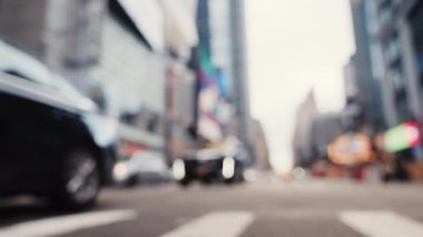Intersection with Crosswalk and Traffic on a Road of New York. Defocused Cityscape. Slow Motion Low Angle Shot