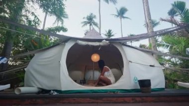 Pretty Woman Sitting Inside the Luxury Tent House and Working on Her Laptop. Freelance Job Concept. Slow Motion Zoom In Shot