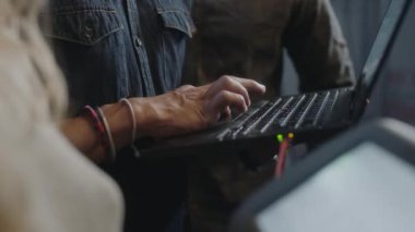 Close Up Handheld Shot Of Three People Transferring Data From Laptop To Monitor