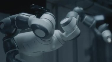 Handheld Close Up Shot Of Robot Moving Backwards And Forwards And Rotating Arms In Laboratory