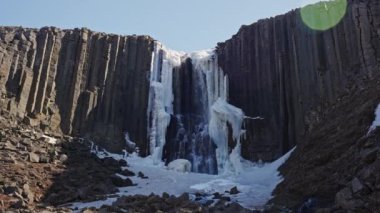 Slow Motion Wide Tilting Down Shot Of Water Cascading Down Basalt Cliffs Of Studlagil Canyon, Glacier Valley, Jokuldalur, Iceland